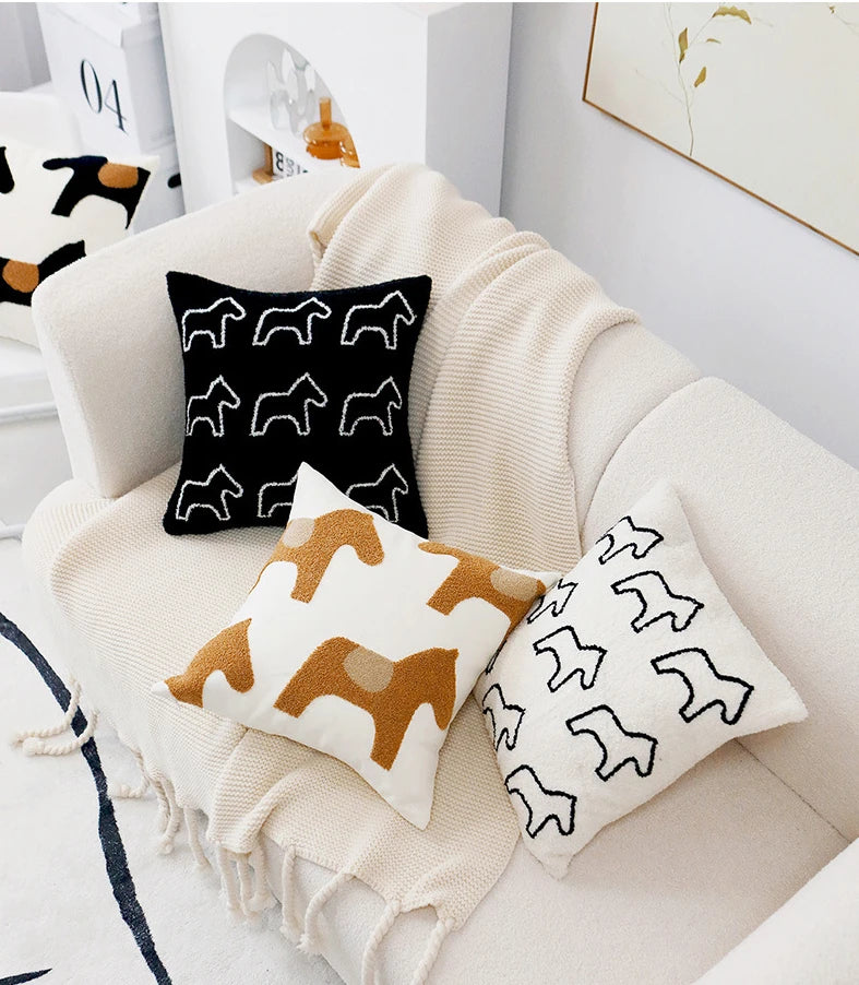 Decorative pillows with animal patterns on a beige armchair.