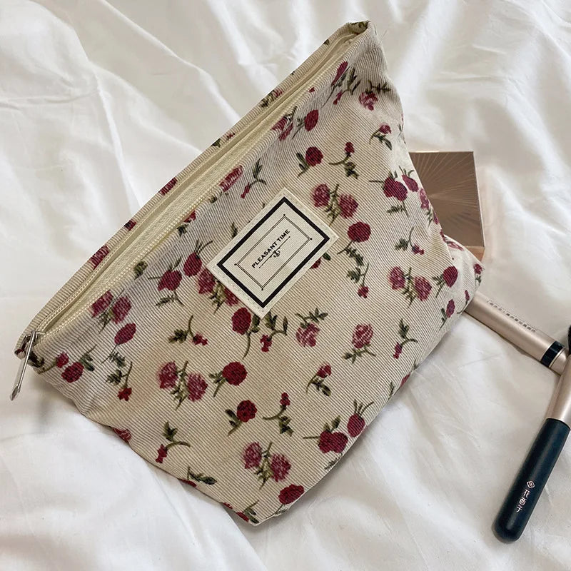 Floral patterned pouch with a brand label on a white surface