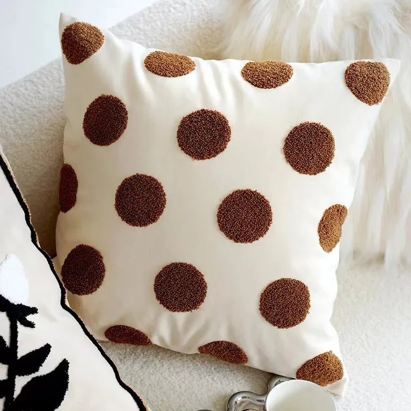 White pillow with brown polka dots on a white surface