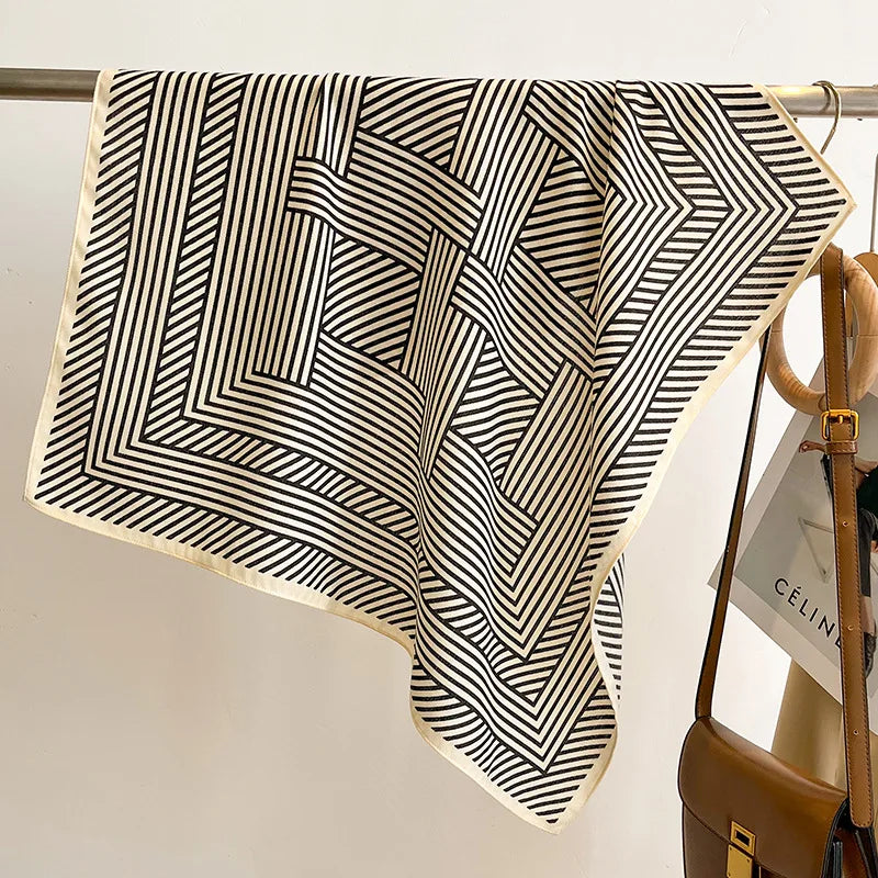 Black and white patterned fabric draped over a rack with a handbag in the background.