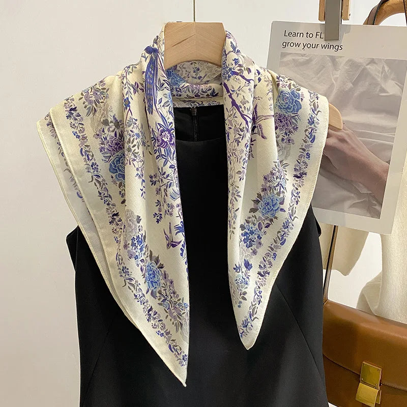 Floral patterned scarf draped over a black garment on a wooden hanger.