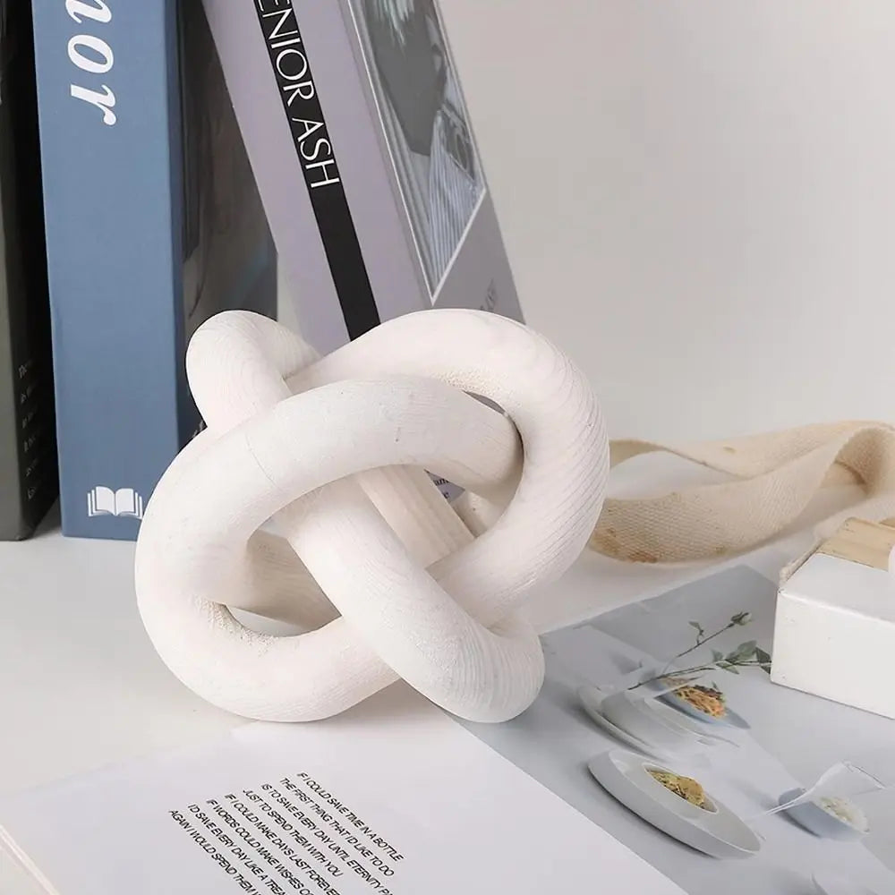 Decorative knot on a surface with books and stationery items in the background