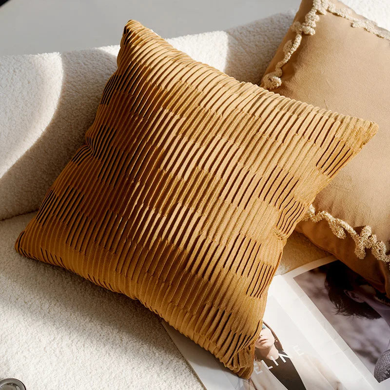 Brown textured pillow on a light-colored sofa with a magazine underneath