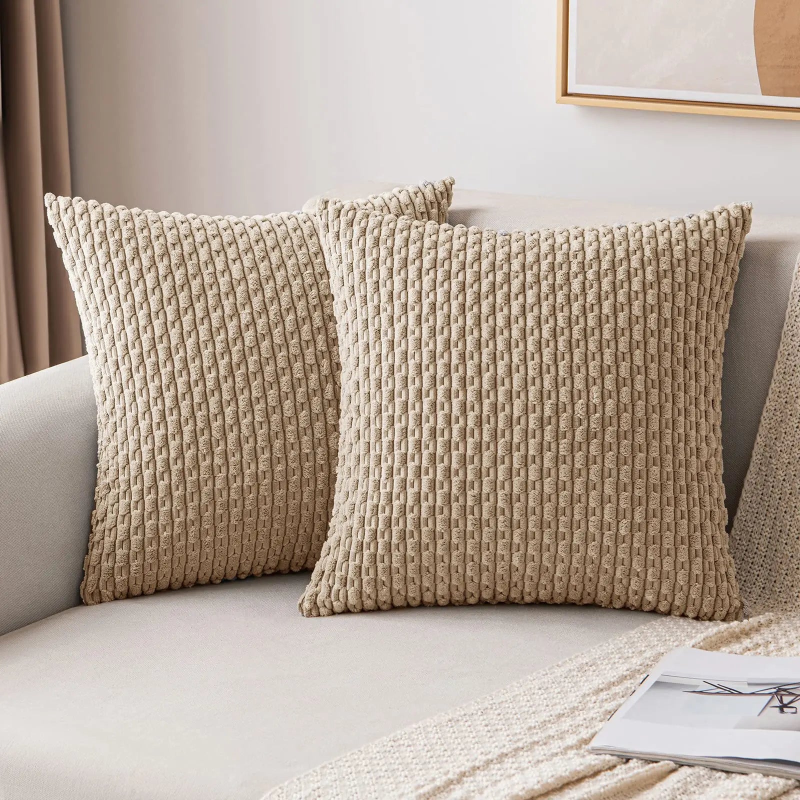 Beige textured throw pillows on a sofa with a neutral background