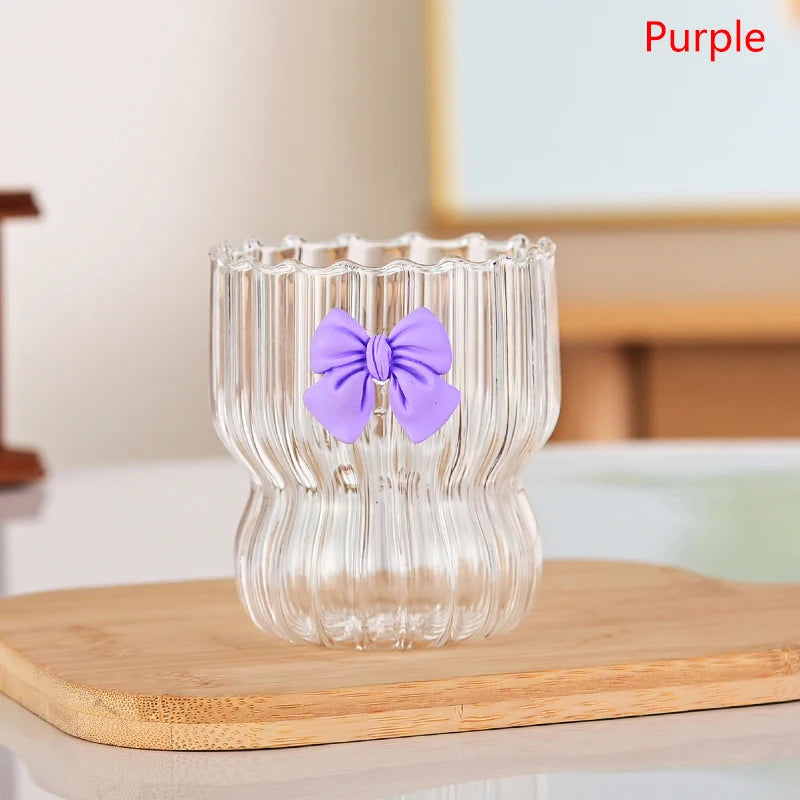 Clear glass with a purple bow on a wooden surface