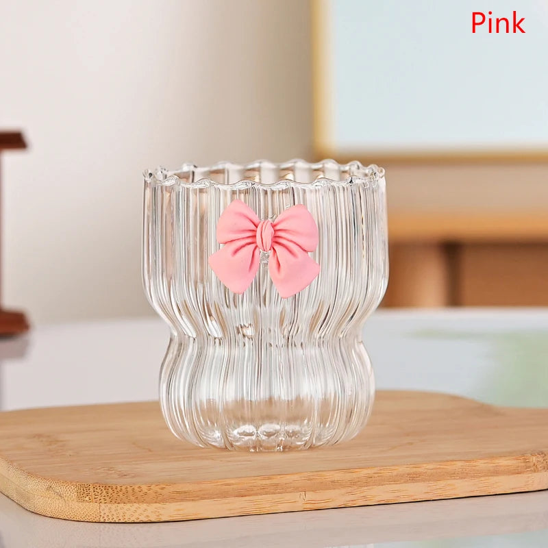 Clear glass with a pink bow on a wooden surface