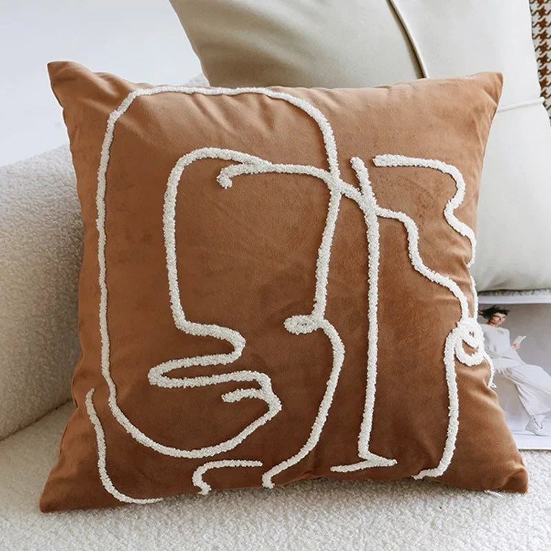 Brown pillow with white abstract design on a beige couch