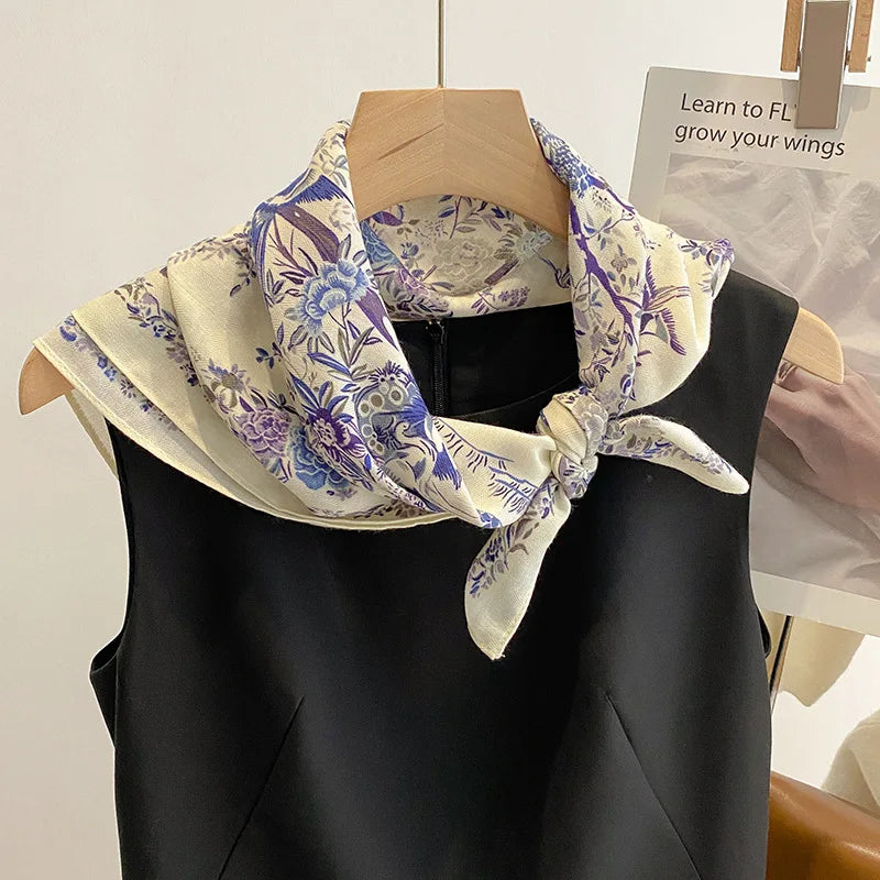 Black sleeveless top with a floral patterned scarf on a mannequin against a neutral background.