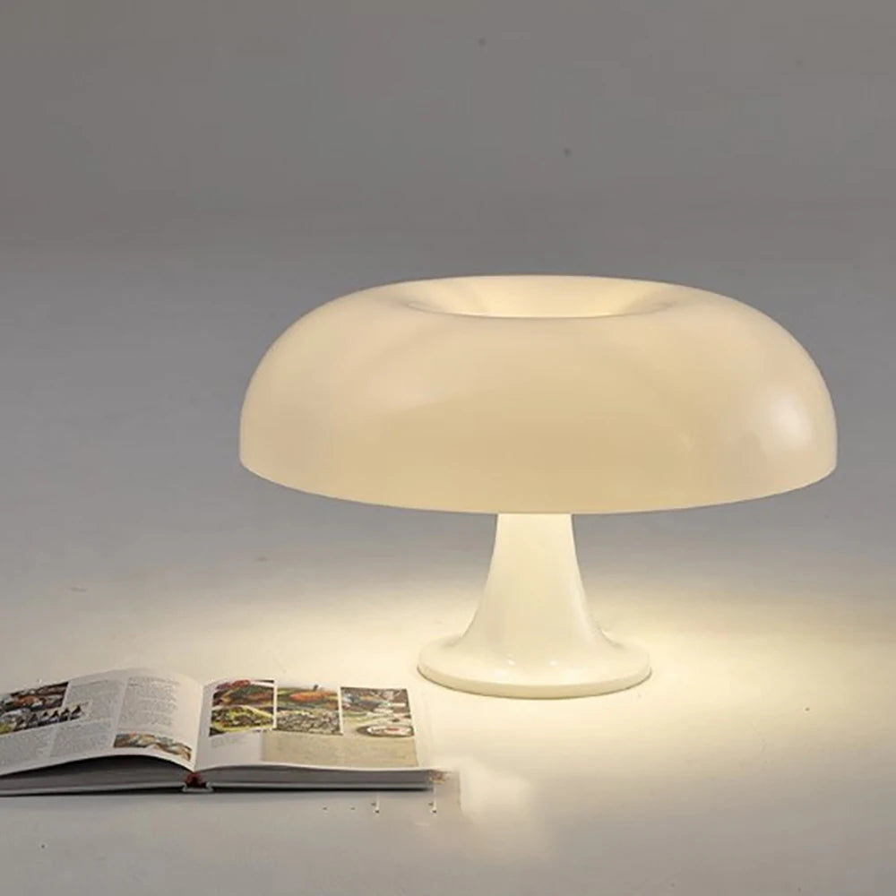Mushroom-shaped table lamp on a gray surface with an open book